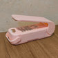 Hand holding the Mini Plastic Bag Sealer, highlighting its ergonomic design.