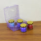 Close-up of wax candle contained in colorful glass jar with gold lid