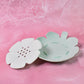 Close-up of the flower-shaped plastic soap dish, highlighting the detailed design.