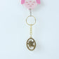 Angled view of Maa Durga Oval Frame Keychain showcasing metallic golden finish