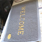 The easy-to-clean Welcome Door Mat with water droplets, demonstrating its quick-dry microfiber material.