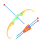 An Indian child joyfully aiming the toy bow and arrow set at a target board outdoors.