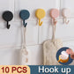 Self-adhesive utility hooks holding kitchen utensils and towels.