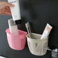 Hanging plastic storage basket in a modern bathroom, neatly holding shampoo and body wash.