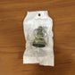 Metal temple bell keychain resting on textured surface background