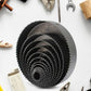 A hole saw attached to a drill, poised to make a cut in a piece of plastic material.