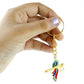 Krishna flute keychain resting on a wooden surface showing its metal finish