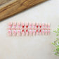 Full set of nude fake nails displayed for manicure use