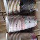 Mixed-design disposable paper cups stacked neatly, convenient for storage.