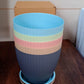 An empty black plastic flower pot with its tray, ready for planting and gardening use.