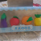 Assorted mini 3D fruit and vegetable erasers for kids' school supplies.