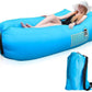 An adult relaxing on the Trekola inflatable camping lounger at a campsite.