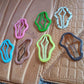 Hand holding a selection of colorful metal hair clips