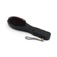 User holding the electric hair massager comb for a relaxing scalp massage.