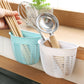 White hanging plastic storage basket mounted on a tiled wall, holding toiletries and soap.