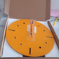 Yellow round wall clock displayed in contemporary room setting