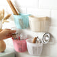 Back view of the hanging plastic storage basket, highlighting its adhesive strip for wall mounting.