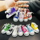 Trendy yellow designer-style shoe keychain on a white background.