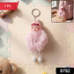 Close-up view of plush doll and fluffy fur ball keychain showing soft texture