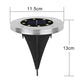 Single solar LED garden light glowing brightly at night in outdoor garden setting