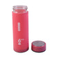Person drinking water from glass bottle with silicone sleeve