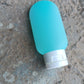 A single 60ml leakproof plastic travel bottle in a vibrant assorted color, ready for your next adventure.