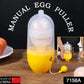 Close-up of the Manual Egg Scrambler's transparent casing, showing an egg secured inside the silicone holder.
