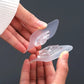 A clear adhesive wall hook holding a heavy coat, showcasing its 13 lbs weight capacity.