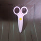 A child happily using the child-safe plastic scissors for an art project.