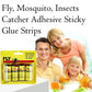 Fly catcher sticky strip hanging outdoors, trapping insects.