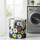 Collapsible canvas laundry bag standing upright, used for toy storage in a modern living room.