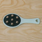 Handheld roller ball massager in retail packaging.