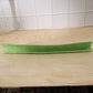 Side angle view of the flexible kitchen sink splash guard on a wooden counter.