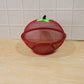 Fruit basket on kitchen counter with apple-shaped dome cover