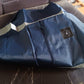 Blue travel bag packed with various items, demonstrating its ample storage for a trip.