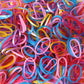 A neatly stacked pile of colorful multicolor rubber bands on a clean white background.