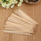 Hand holding a natural bamboo skewer with perfectly grilled meat.