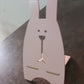The wooden rabbit mobile stand securely holding a smartphone for easy viewing.