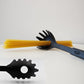 Black heat-resistant pasta server scooping spaghetti from a pot, showcasing its non-stick design.