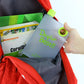 The compact notebook water bottle fitting easily into a laptop bag, demonstrating its portability.