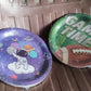 Neatly stacked disposable paper plates with festive birthday designs.