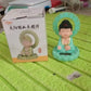 The solar Buddha statue on a car dashboard, bringing calm to daily commutes.