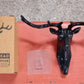 Three deer head wall hooks in black, white, and grey mounted on a wall.