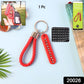 Close-up of anti-lost keychain with unique number plate and braided strap