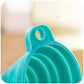Detailed view of the narrow spout of the red silicone funnel for precise pouring.