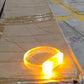 An LED running bracelet brightly glowing in a dark outdoor night environment.