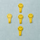 A set of five white self adhesive hooks displayed on a clean surface.