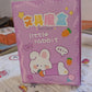 Top view of a cartoon school box, showcasing multiple stationery items and a pen refill.