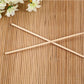 A hand holding a bamboo BBQ skewer with various ingredients for grilling.