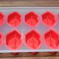 Assorted colorful silicone ice cube moulds featuring various fruit designs for creative desserts.
